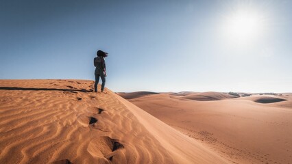 View of a female standing in the desert sand and enjoying the magical view