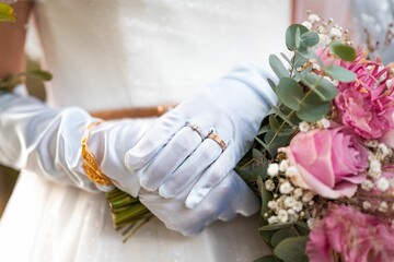 Closeup shot of the bride with wedding rings and bouquet