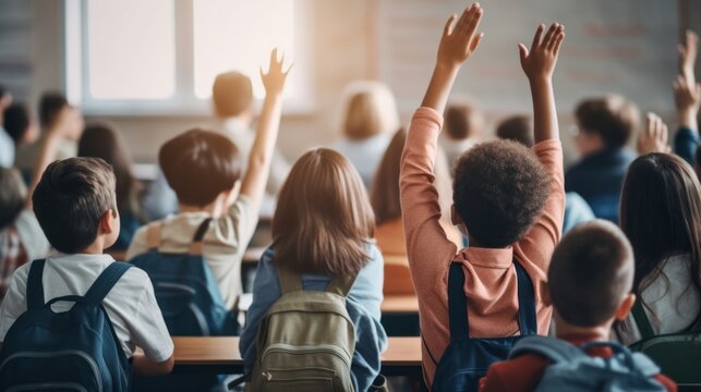 A classroom full of students are raising their hands in the air