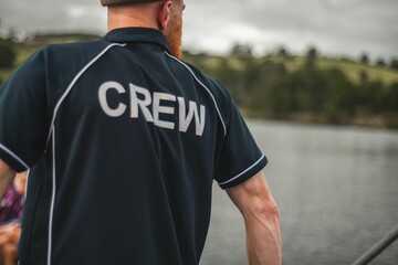 Young man wearing a polo shirt with the word Crew