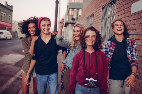 Group of young friends walking and laughing in the city