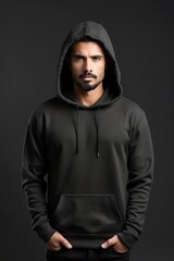 Portrait of handsome young man in black hoodie. Isolated on grey background.