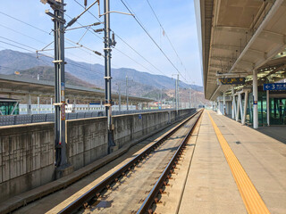 Train station in the middle of nowhere in Korea, it's totaly empty with mountains in the background.