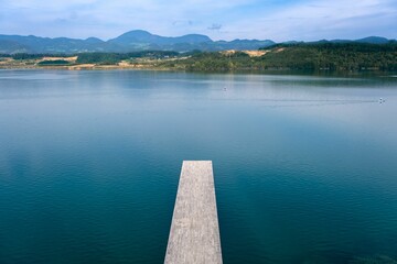Beautiful shot of a narrow wooden pier over the lake