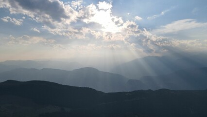 Sunbeams spreading over the skyline of the Italian Dolomites mountains