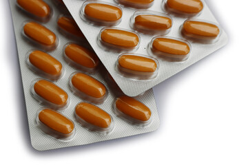 Pharmaceutical medicine capsules isolated on white background. Orange pills in blister packaging - obrazy, fototapety, plakaty
