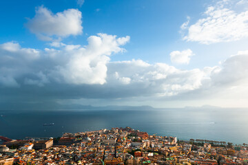 Panoramic view of Naples city and Gulf of Naples, Italy. Blue sea and the sky with clouds at sunset