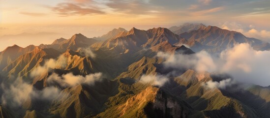 Aerial view of mountains in orange clouds at sunset in summer. - obrazy, fototapety, plakaty