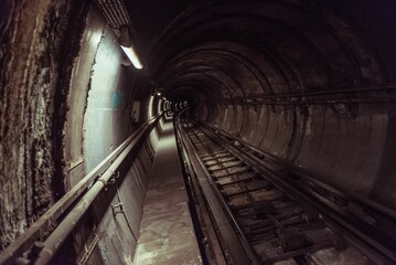 Dark tunnel in the metro station with subway rails