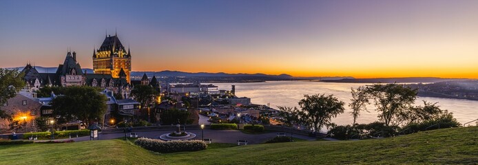 Panoramic view of the Chateau Frontenac surrounded by greenery in Quebec, Canada at sunrise