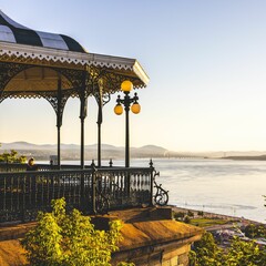 Beautifully designed gazebo near a tranquil river in Quebec during a scenic sunrise