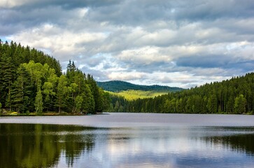 Landscape of a river in a forest under a cloudy sky on a stormy day in the countryside