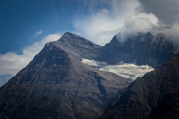 Landscape of a green mountain with a foggy sky and white clouds at sunset