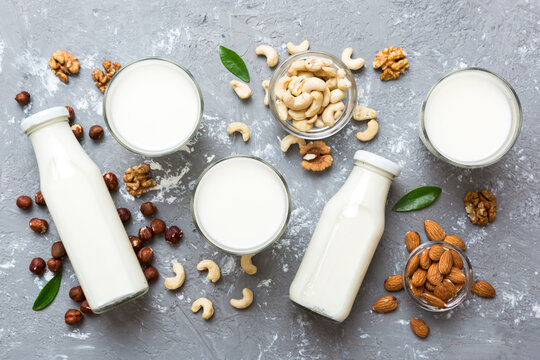 Set or collection of various vegan milk almond, cashew, on table background. Vegan plant based milk and ingredients, top view