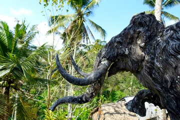 Beautiful man-made elephant art work among the palm trees