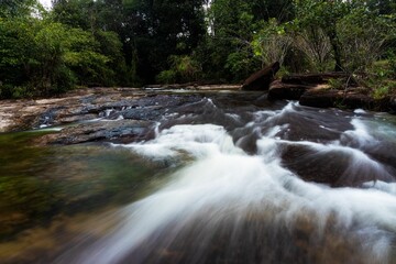 Beautiful long exposure shot of a flowing rocky river in a forest