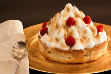 Closeup of a cake with raspberry and meringue