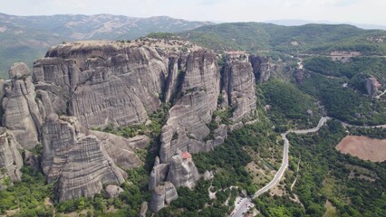 Aerial view of rock formations surrounded by dense trees in Meteora