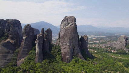 Aerial view of rock formations surrounded by dense trees in Meteora