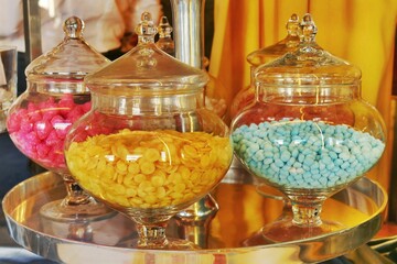 Colorful sugar candies in glass bowls displayed at a pastry shop