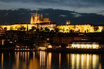 Beautiful scenery of illuminated Prague Castle at night reflected on the Vltava river