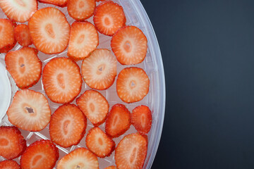 Thinly sliced strawberries on round drying racks. Drying strawberries in a dehydrator.