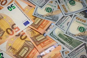 Closeup view of one hundred dollars banknote with euro money banknotes around as financial...