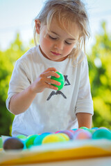 Nice Child is Considering Colorful Easter Eggs