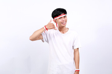 Happy friendly Young asian boy with red white ribbon celebrating Indonesia independence day while...