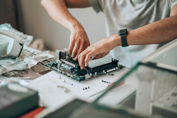 Component Connection : A close-up of hands meticulously assembling a desktop's motherboard,...