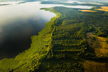 Top view of lake Drivyaty in the forest in the Braslav lakes National Park at sunset, the most beautiful places in the city of Belarus.An island in the lake.Belarus. - obrazy, fototapety, plakaty