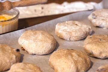 uncooked  scones  fruit t  buns   on  tray  waiting  for the  oven 