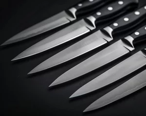 Fotobehang A set of kitchen knives from an eyelevel angle, revealing their sharp edges © Expert Mind
