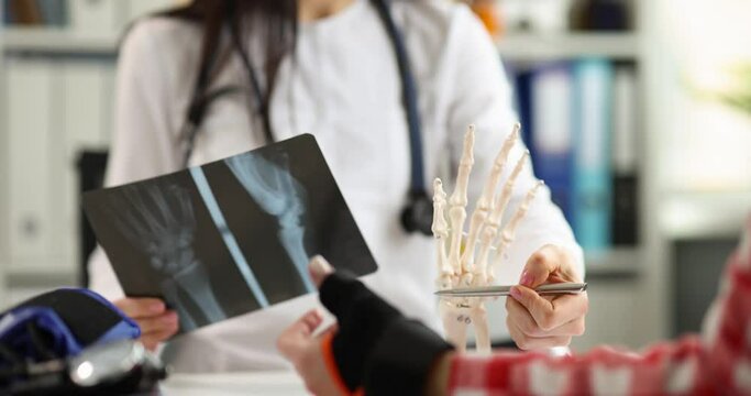 Doctor and patient are examining an x-ray with hand injury. First aid for injuries concept