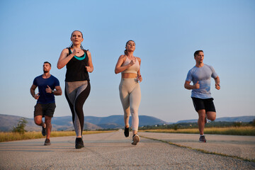 A group of friends maintains a healthy lifestyle by running outdoors on a sunny day, bonding over...