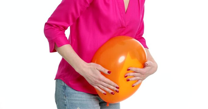 Woman holding on to sick stomach with balloon on white background 4k movie. Abdominal bloating and flatulence concept