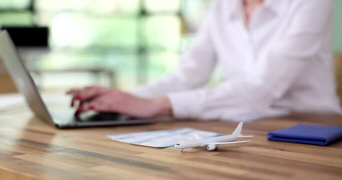 Agent typing on laptop keyboard near toy plane and flight tickets closeup 4k movie. Air travel concept