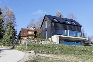 HUBA, POLAND - MARCH 28, 2024: .Two houses on the mountainside - one is historic and the other is...