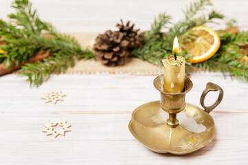 Traditional Christmas decorations with fir garland and dried oranges. Small candle holder in front of it.