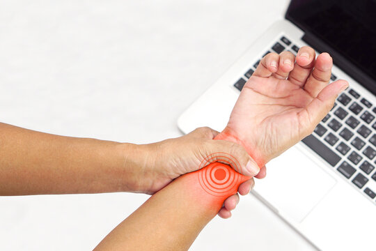 Woman with wrist pain from using a laptop on white background. Healthcare and office syndrome concept.