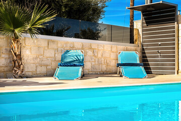 Inviting Private Swimming Pool Concept: Sun-drenched sunbeds lining the terrace of a luxurious...