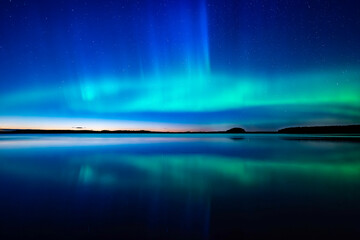 Northern light dancing over calm lake in north of Sweden.Farnebofjarden national park. - 774155363