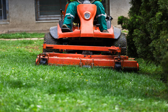 Gardener mowing lawn with riding mower