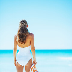 Happy young woman with hat on beach. rear view - 774166325