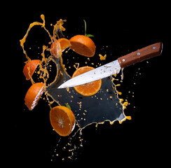 Sliced of orange with juice splash on black background - 774168577
