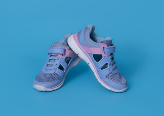 Baby's little blue sneakers on a blue background. - 774169561