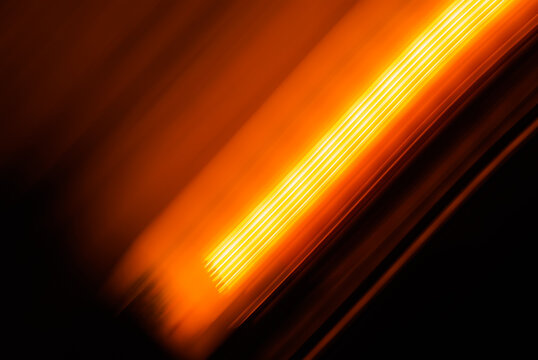 Abstrack background with bright orange lights on dark, long exposure 
