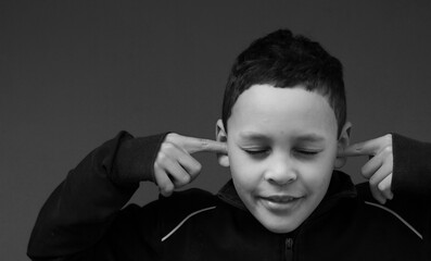 boy suffering from deafness and hearing loss on grey background stock photo