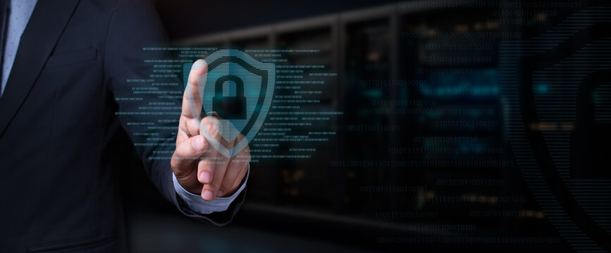 cybersecurity concept. businessman touches hologram of shield with padlock surrounded by binary code