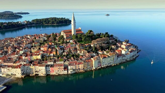 Colorful houses and Church of Saint Euphemia in old town of Rovinj. Rovinj during sunrise, Istrian peninsula, Croatia. Aerial shot, 4K